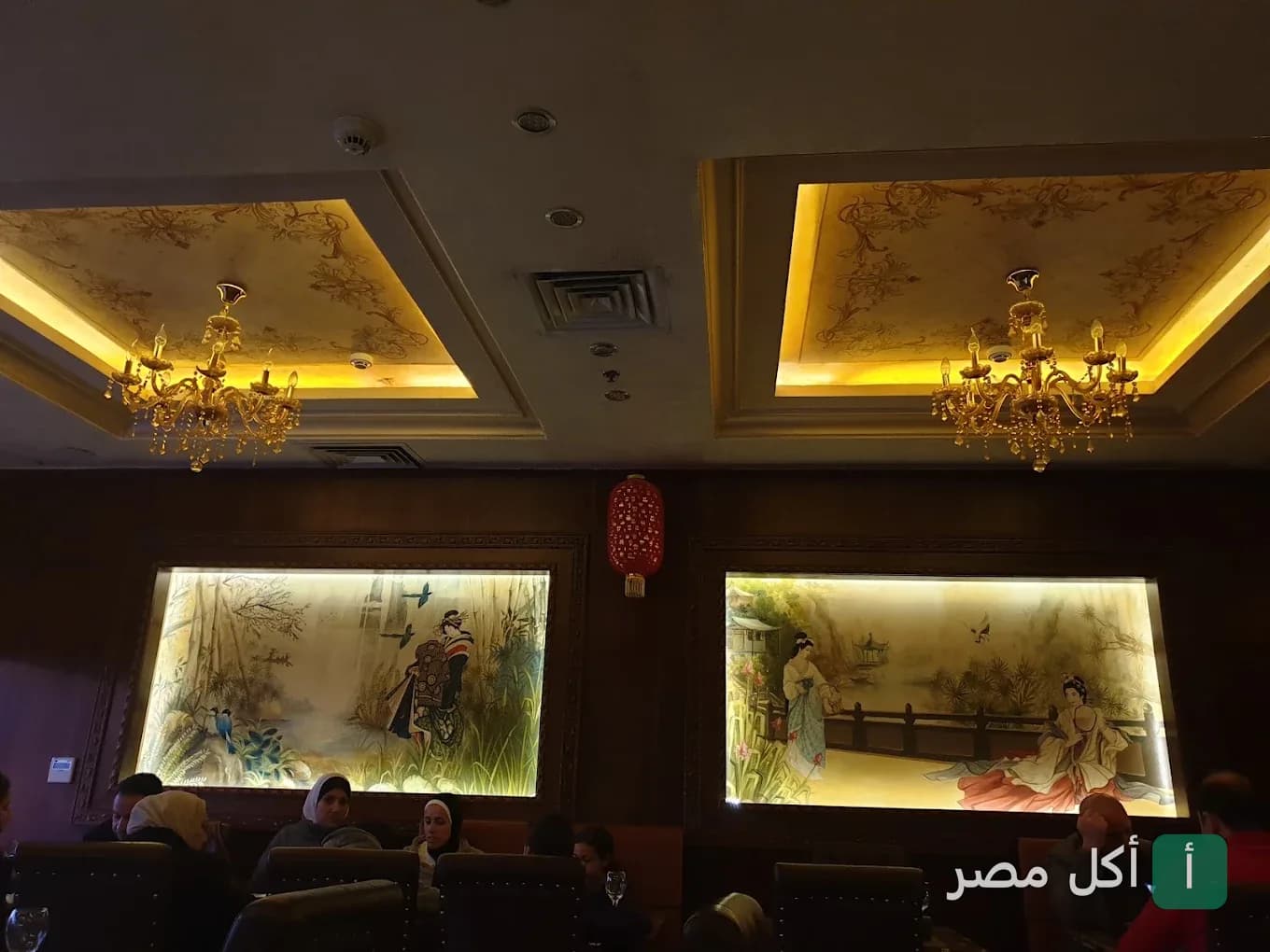 ديكور داخلي في مطعم أريجاتو سوشي آند جريل بالشيخ زايد مع لوحات فنية شرقية وإضاءة كلاسيكية.