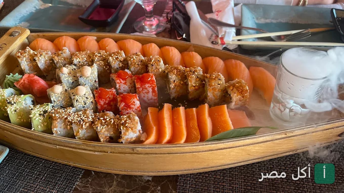 طبق سوشي متنوع يقدم على قارب خشبي في مطعم أريجاتو سوشي آند جريل بالشيخ زايد.