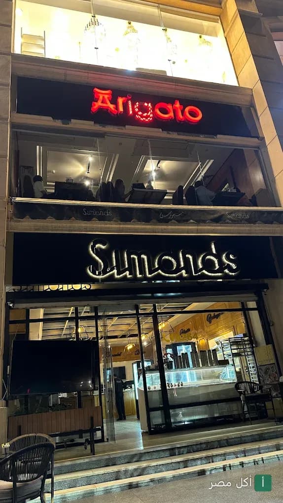 واجهة مطعم أريجاتو سوشي آند جريل في الشيخ زايد، يظهر اسم المطعم بإضاءة نيون حمراء في الطابق العلوي.