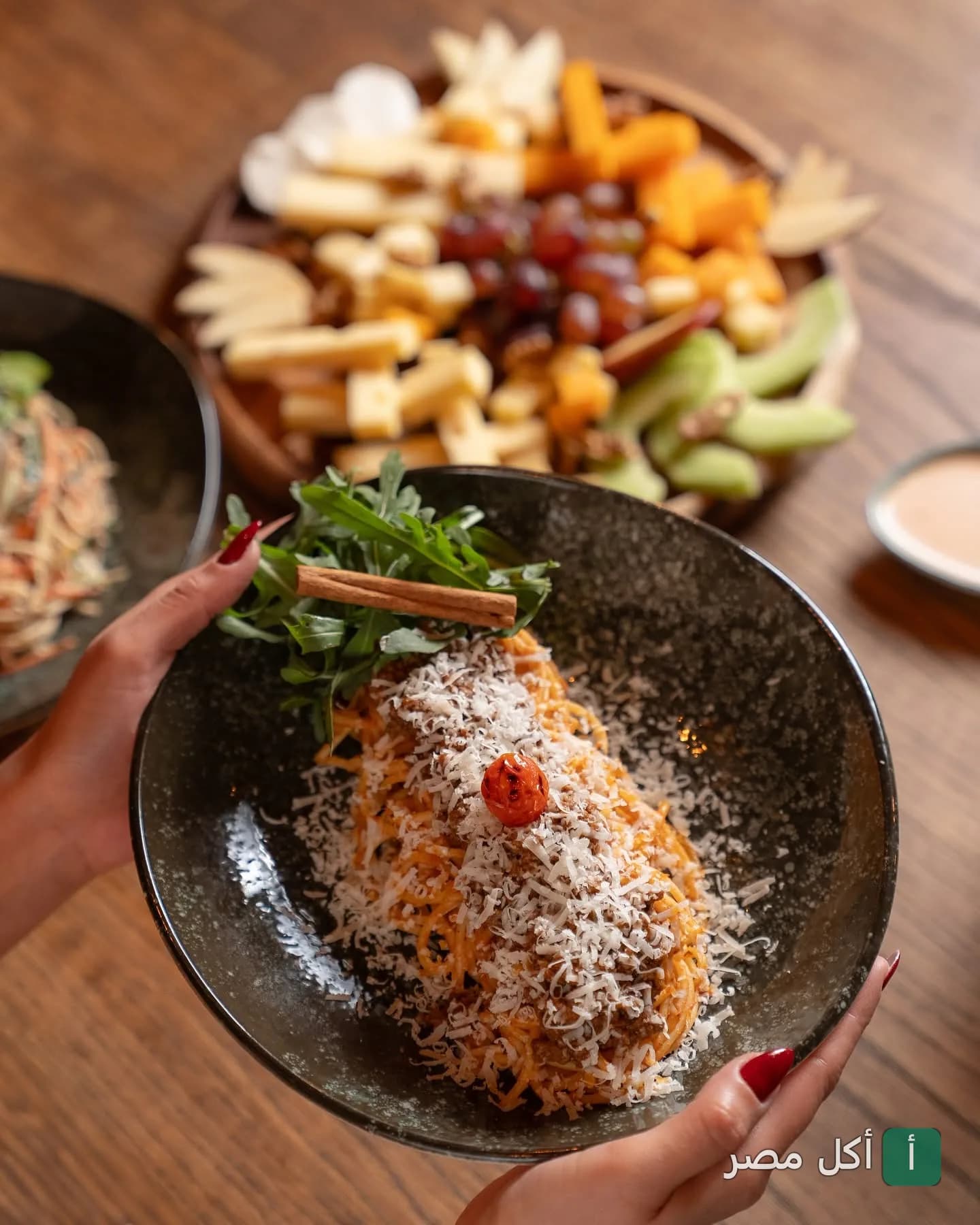 طبق مكرونة بصوص الطماطم والجبن المبشور مع طبق جانبي من الجبن والعنب في مطعم كاسا دي فريدة بالشيخ زايد.