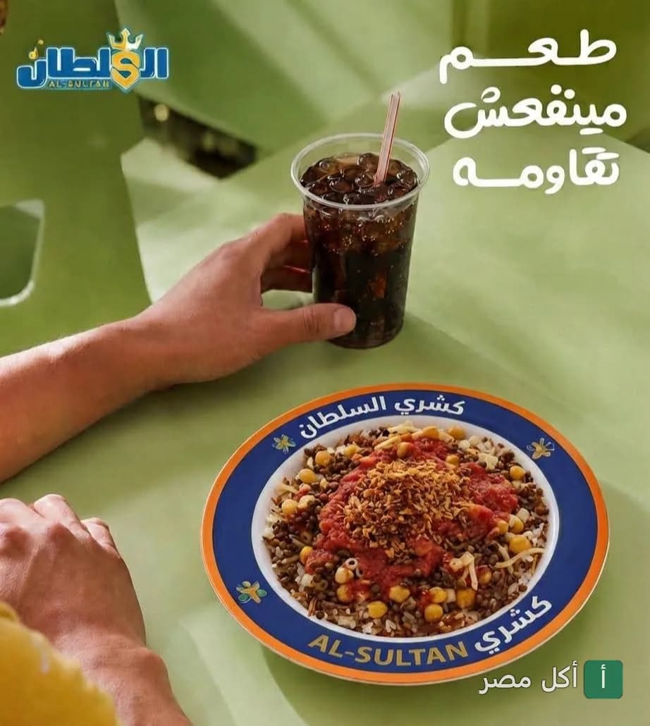 طبق كشري السلطان في الوراق مع كوب مشروب غازي على طاولة.