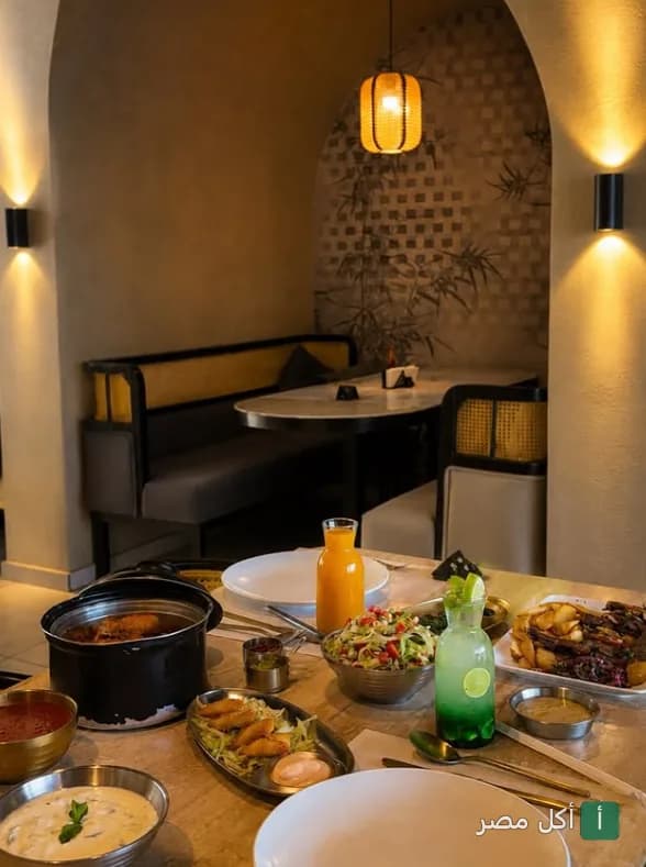 مائدة طعام متنوعة في مطعم دار نوره بالوراق، تضم أطباقاً ومشروبات في أجواء دافئة.