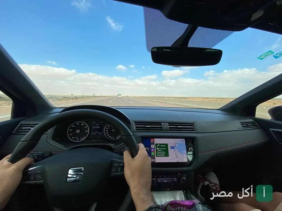 صورة من داخل سيارة أثناء القيادة على طريق سريع، تعبر عن رحلة في طريقها لمطعم أكل و بحلقة في الوراق.