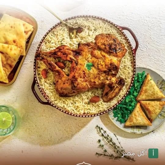طبق دجاج مشوي مع أرز ومقبلات سمبوسة في مطعم دوار العرب بالوراق.