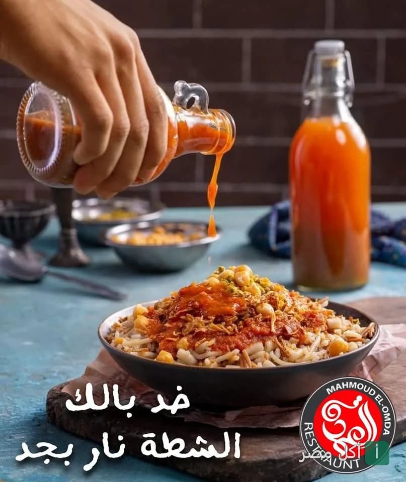 طبق كشري مصري يتم إضافة الشطة الحمراء الحارة عليه في مطعم العمدة بمدينة 6 أكتوبر.
