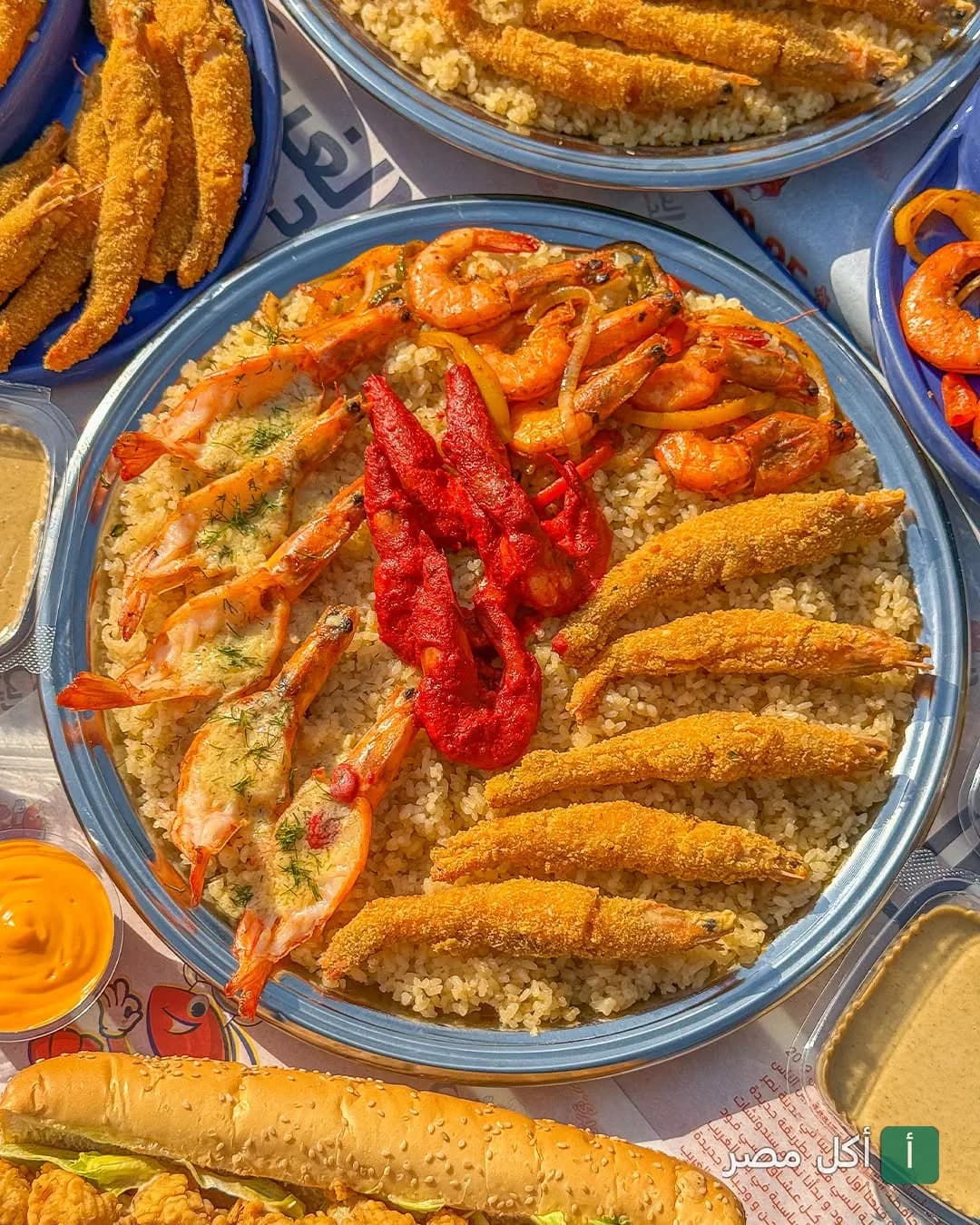 طبق أرز بالمأكولات البحرية المتنوعة مع جمبري مقلي ومشوي في مطعم بلد الغريب بحدائق الأهرام.