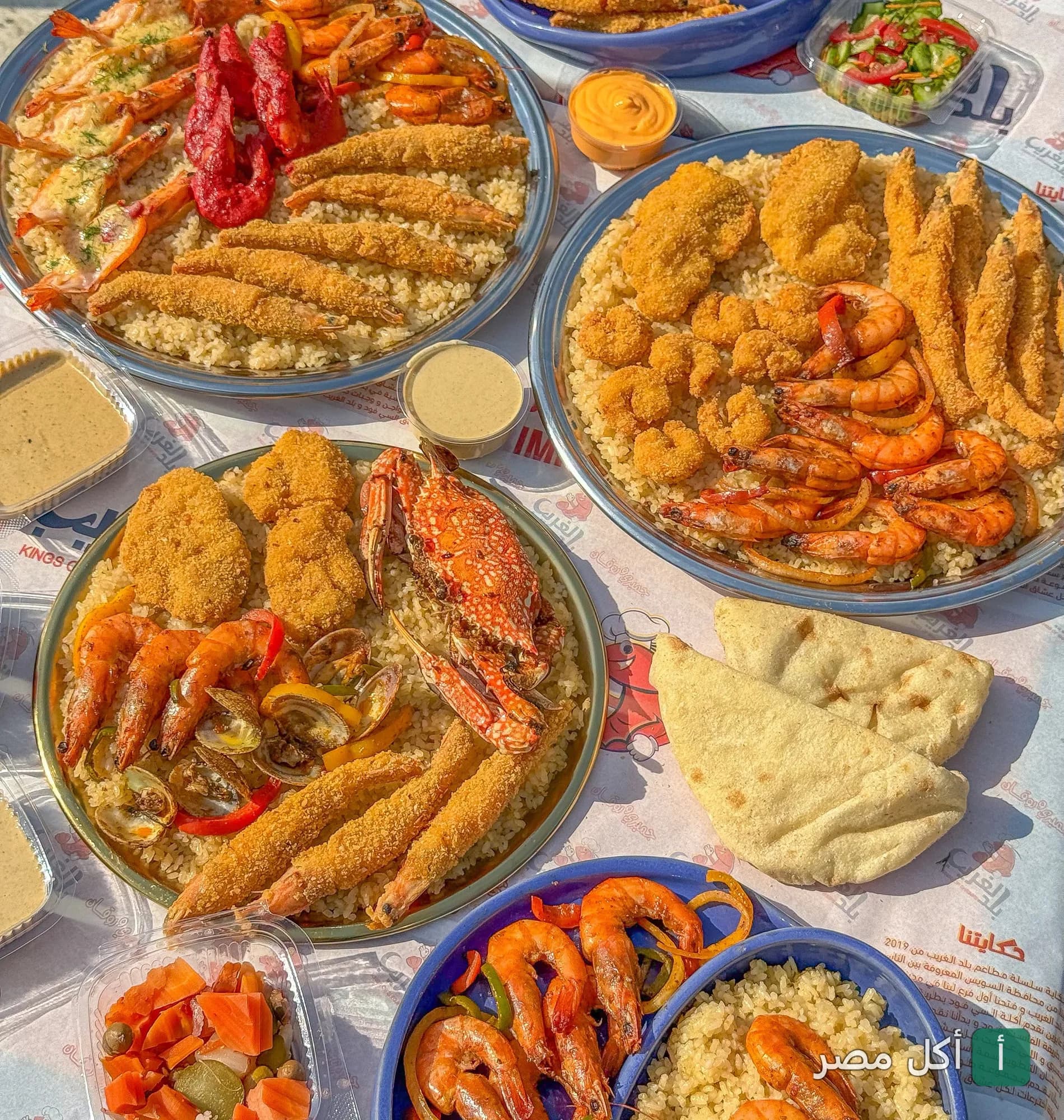 أطباق متنوعة من المأكولات البحرية والأرز في مطعم بلد الغريب بحدائق الأهرام