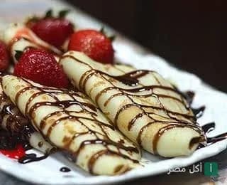 طبق كريب حلو مزين بصوص الشوكولاتة والفراولة الطازجة في مطعم أكيلز.