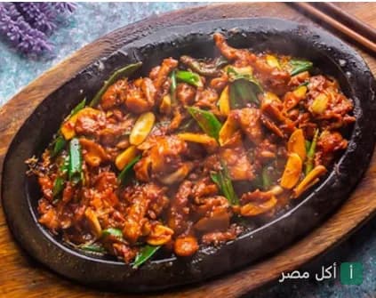 طبق صيني ساخن يقدم على صاج حديدي في مطعم دا فانغ بالهرم، الجيزة.