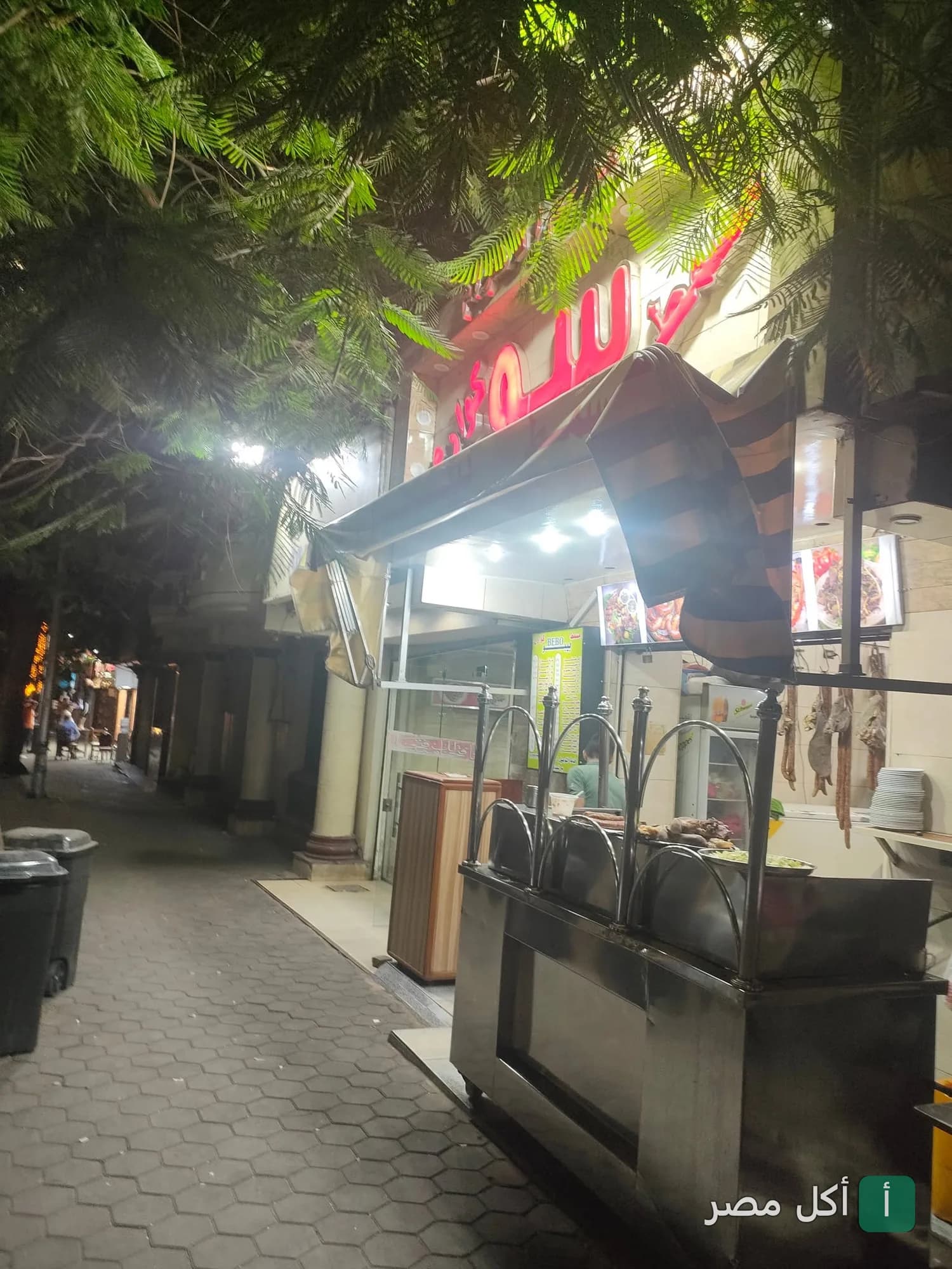 واجهة مسمط بيبو في الهرم بالجيزة ليلاً مع طاولة عرض المشاكل والمأكولات الشرقية.
