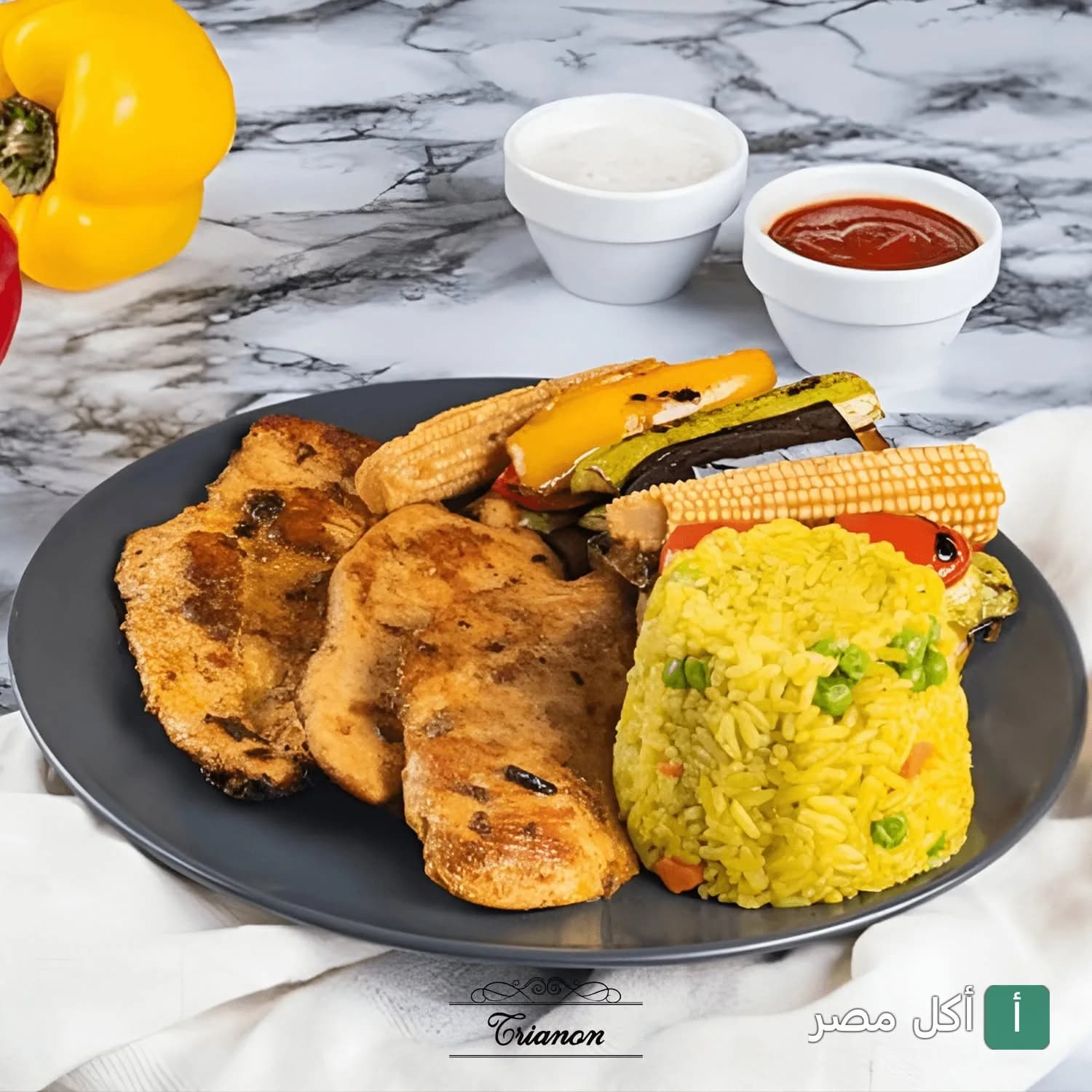 طبق مشويات دجاج مع أرز بالخضار وخضروات مشوية في مطعم ترانون بالجيزة.