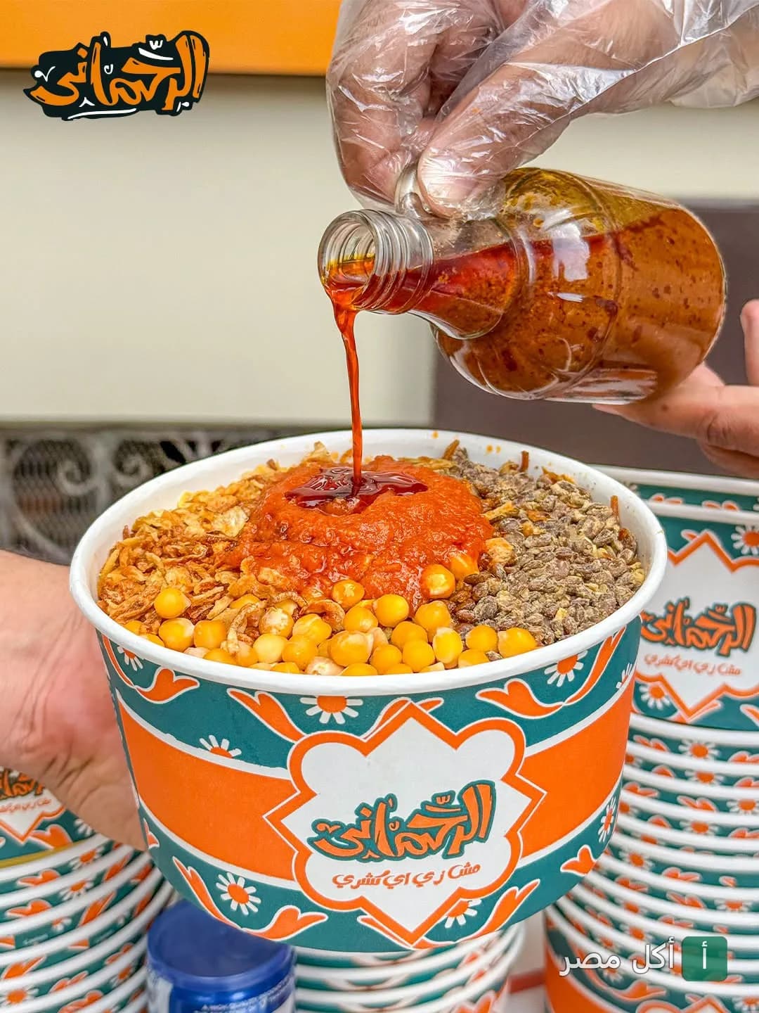 صب صلصة الشطة الحارة على طبق كشري الرحماني 2 في إمبابة.
