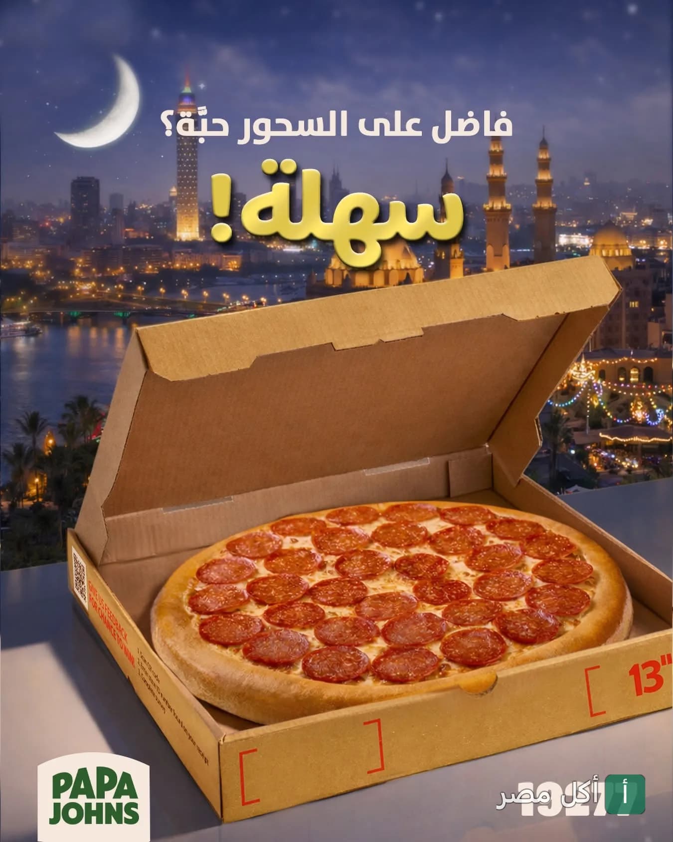 بيتزا بيبيروني من بابا چونز في علبة كرتون مع خلفية رمضانية لمدينة القاهرة ليلاً.