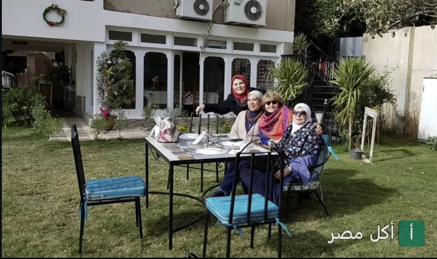 مجموعة سيدات يجلسن في الحديقة الخارجية لمطعم بيت عزيز مصر في الصف.