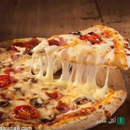 قطعة بيتزا بالجبنة السايحة والمشروم والطماطم من مطعم بيتزا إبن الأكرمين في نزلة البطران.