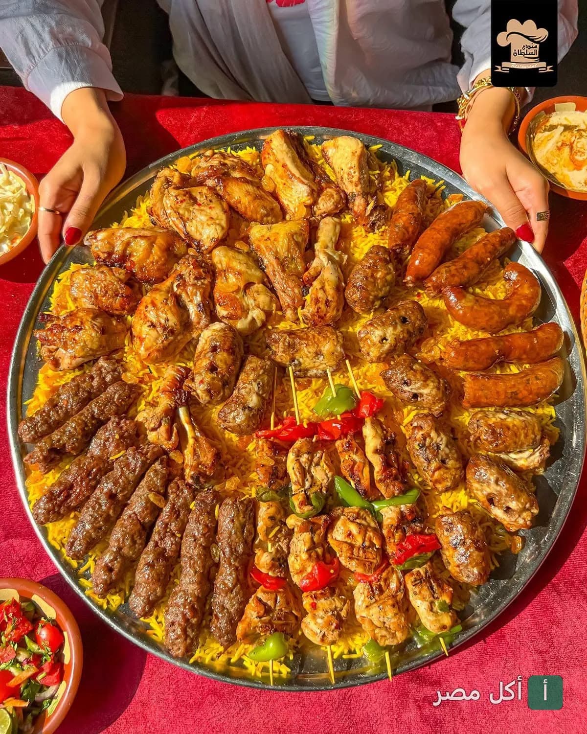 صينية مشويات مشكلة من مطعم مندي السلطان بالصف، تضم كفتة، شيش طاووق، وسجق على أرز أصفر.