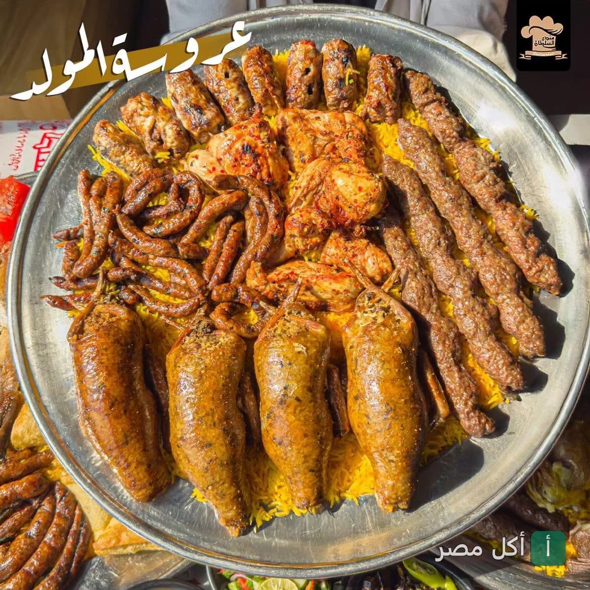 صينية مشويات شرقية متنوعة تشمل كفتة، دجاج، وممبار على أرز أصفر من مطعم مندي السلطان بالصف.