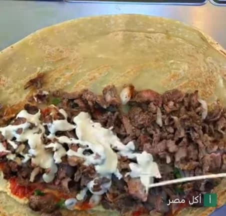 تحضير ساندوتش شاورما لحم مع صوص الطحينة في مطعم لفة شاورما بمحطة الرمل، الإسكندرية.