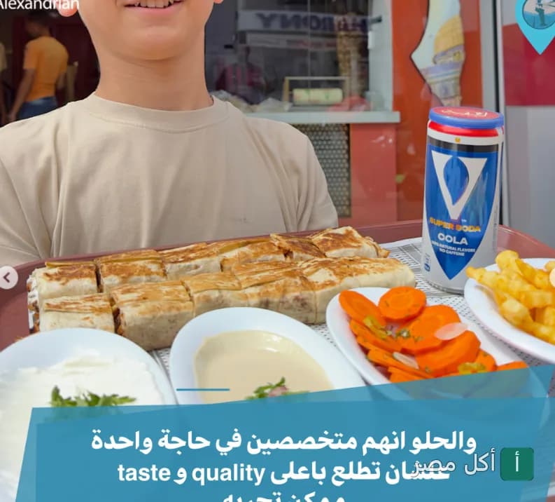 شخص يحمل صينية بها وجبة شاورما مقطعة مع بطاطس مقلية ومقبلات في مطعم لفة شاورما بمحطة الرمل بالإسكندرية.