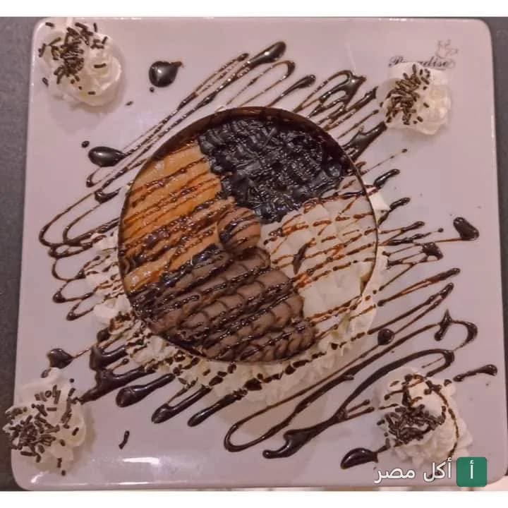 طبق حلوى دائري مزين بصوص الشوكولاتة والكريمة في باراديس كافيه بالعطارين