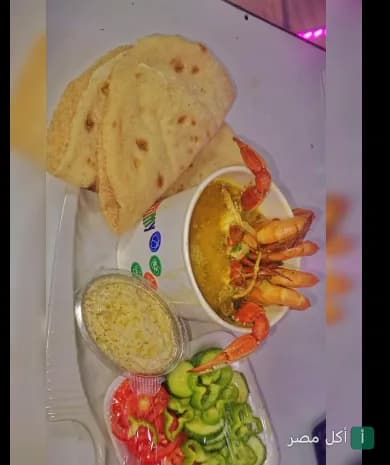 وجبة مأكولات بحرية من مطعم باترفلاي في العطارين، تضم شوربة جمبري وكابوريا مع خبز ومقبلات.