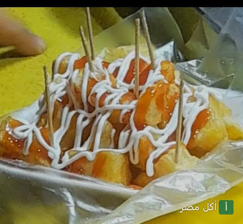قطع مأكولات بحرية مقلية مغطاة بالصوص الأبيض والكاتشب في مطعم باترفلاي بالعطارين.