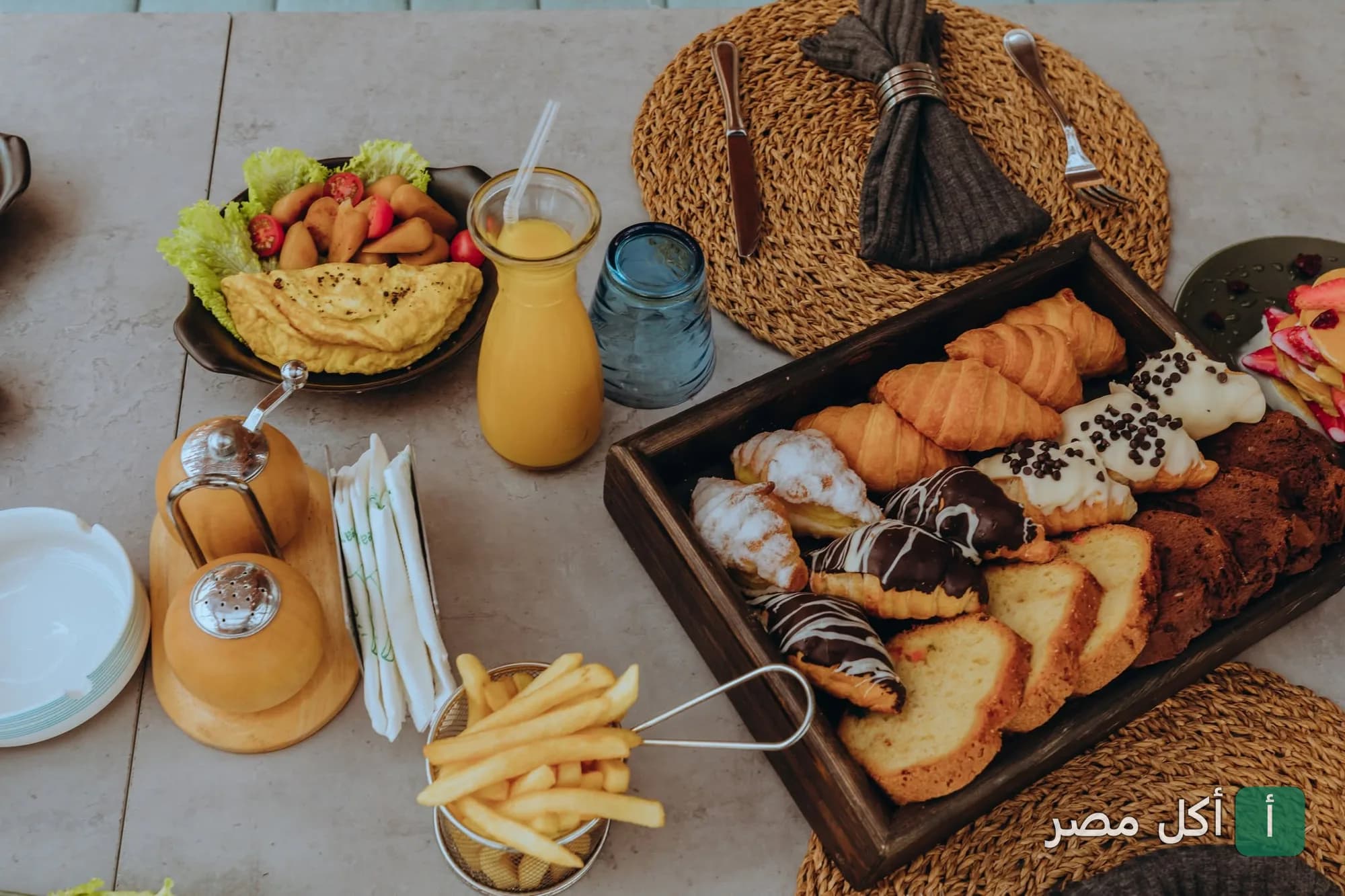 تشكيلة متنوعة من المخبوزات والكرواسون والبطاطس المقلية على طاولة إيزويا ريستورانت في الإسكندرية.