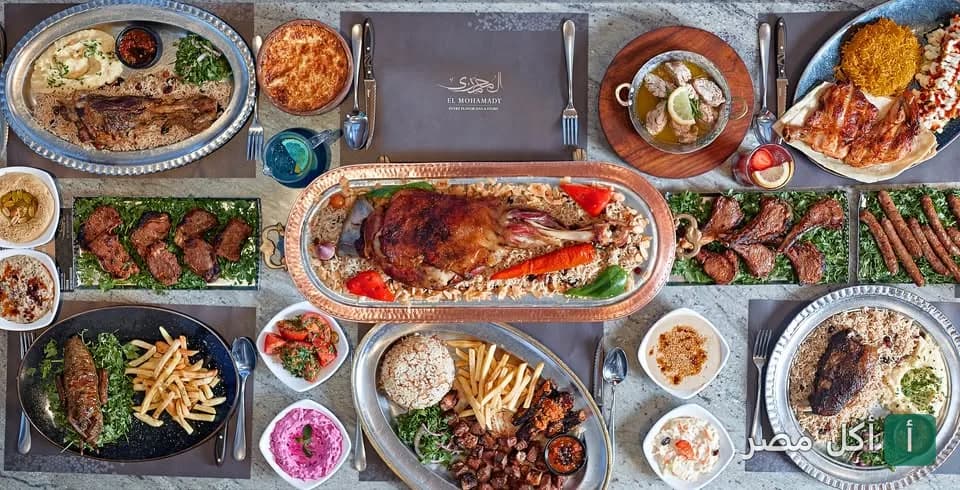 مائدة طعام متنوعة من مطعم المحمدي تضم أطباق مشاوي وأرز ومقبلات شرقية.
