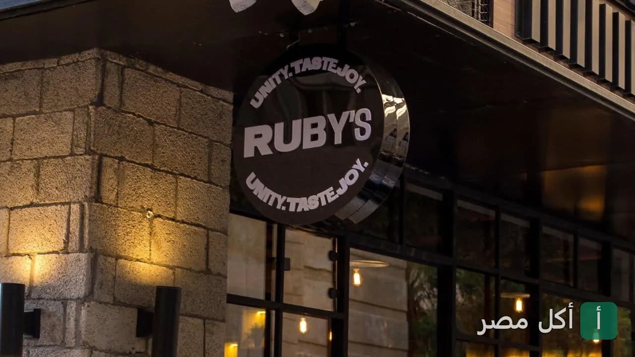 يافطة دائرية مضيئة تحمل اسم روبي’s عند مدخل المطعم في كفر عبده بالإسكندرية.