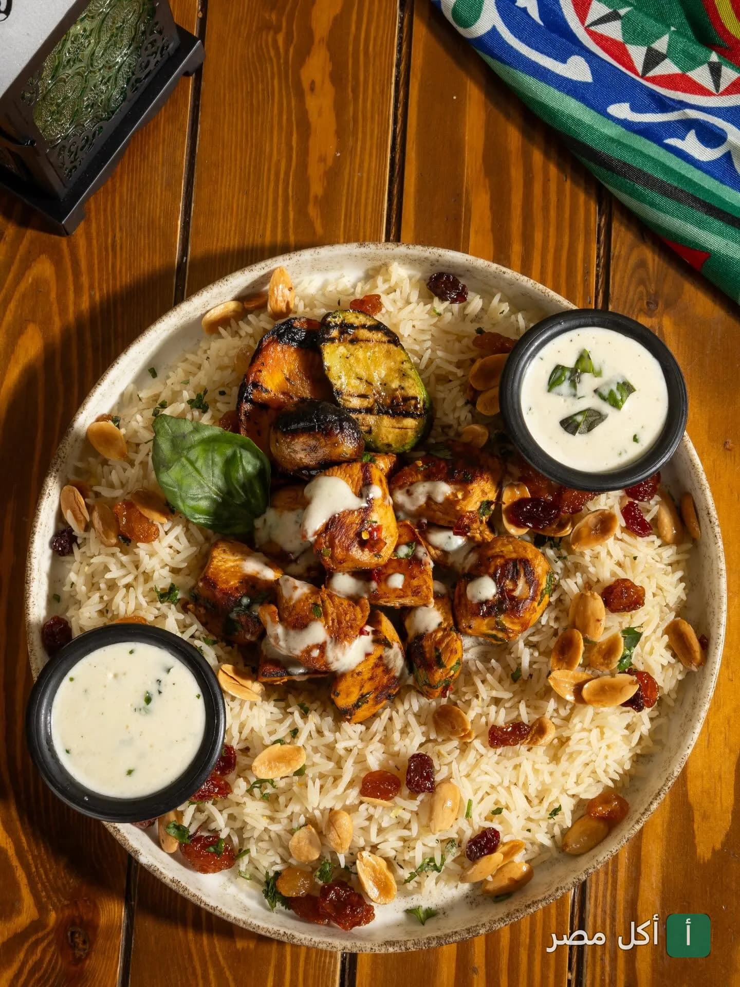 طبق أرز بالدجاج المشوي مع المكسرات والزبيب وصوص الزبادي في مطعم روبي بكفر عبده بالإسكندرية.