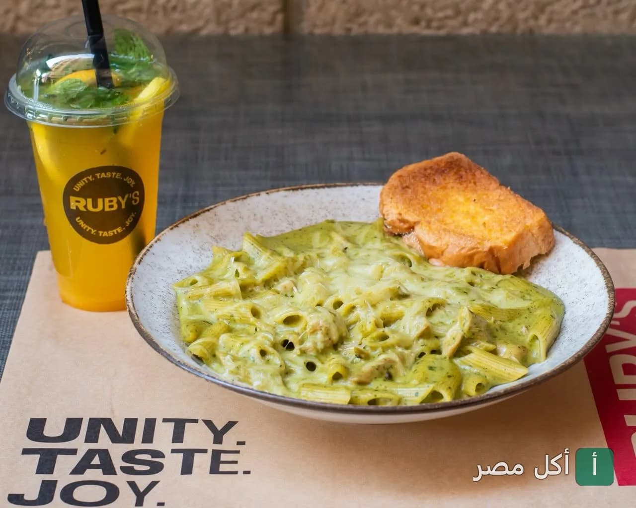 طبق مكرونة بصوص أخضر مع قطعة توست ومشروب بارد في مطعم روبي’s بكفر عبده الإسكندرية.