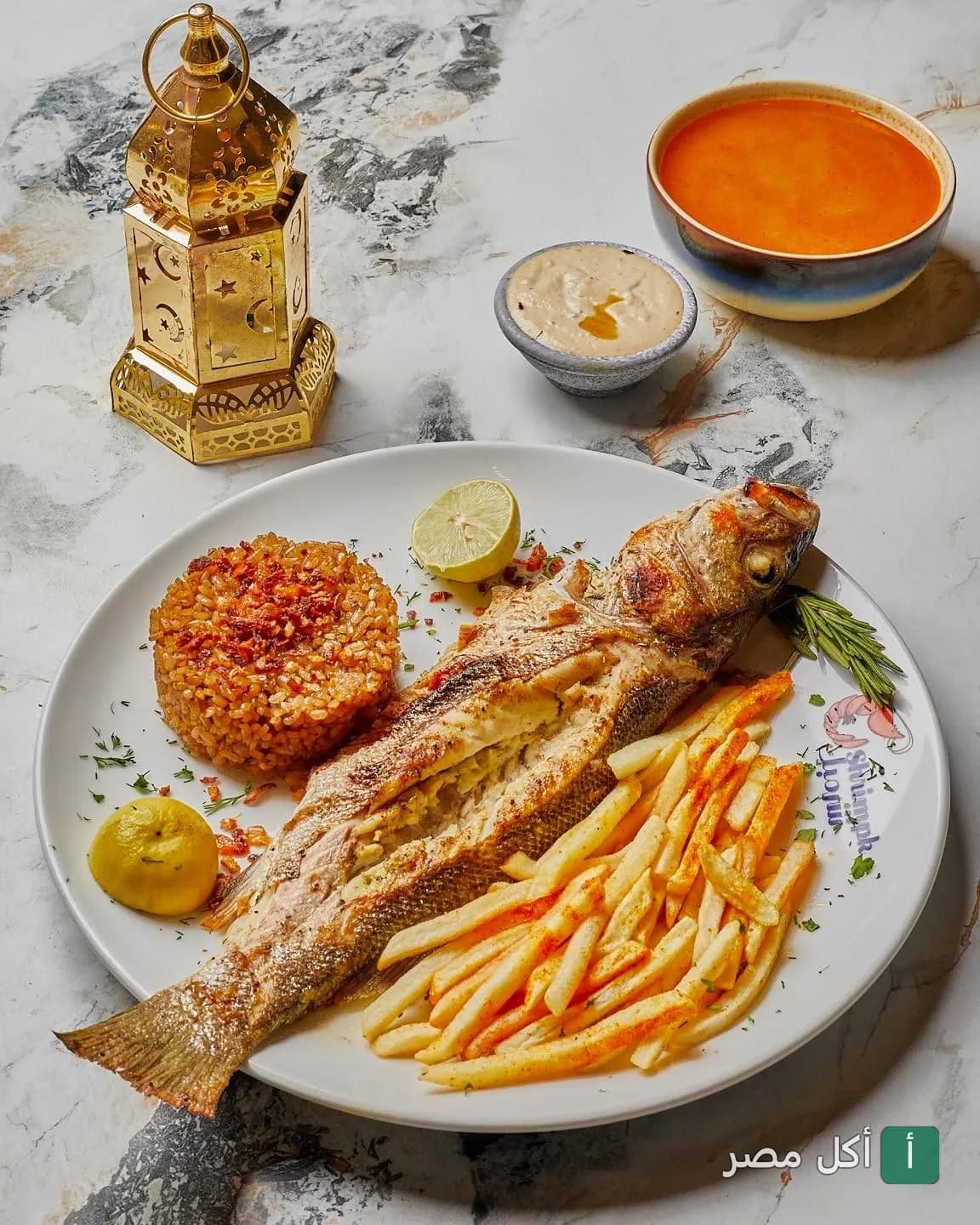 طبق سمك مشوي مع أرز صيادية وبطاطس مقلية من مطعم شريمبك في سيدي جابر بالإسكندرية.
