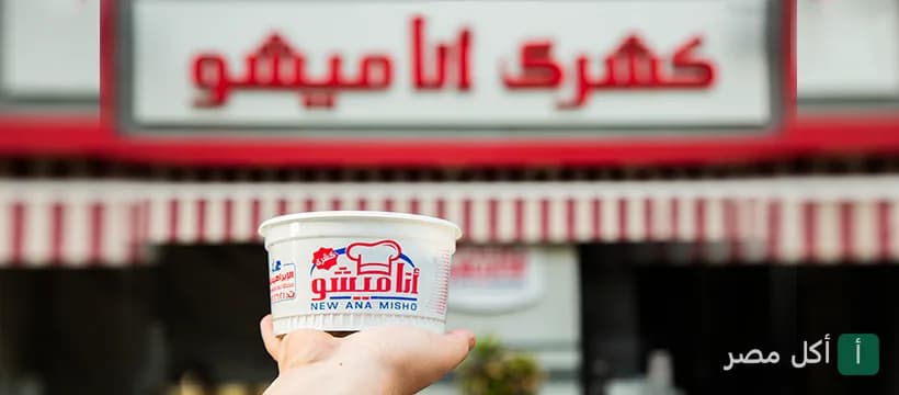 يد تحمل علبة طعام تحمل شعار مطعم أنا ميشو في الإبراهيمية بالإسكندرية.