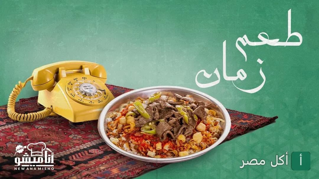 طبق كشري بالكبده من مطعم أنا ميشو في الإسكندرية بجانب تليفون قديم على مفرش تراثي.
