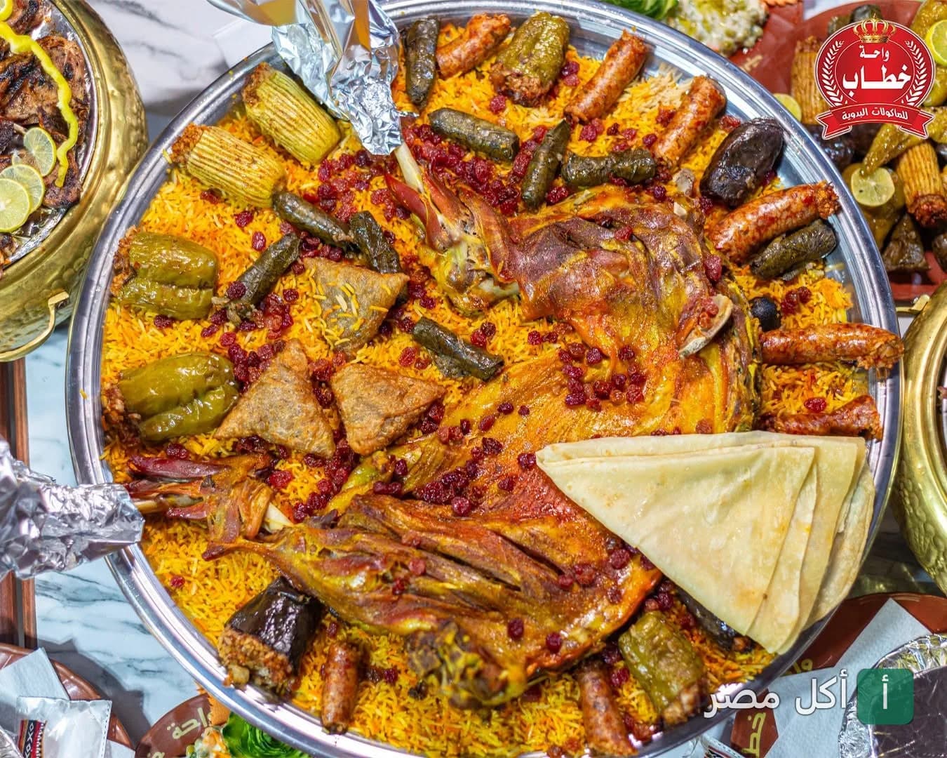 صينية كبيرة من مشاوي واحة خطاب في كارفور الإسكندرية، تحتوي على لحم مشوي وأرز ومحاشي.