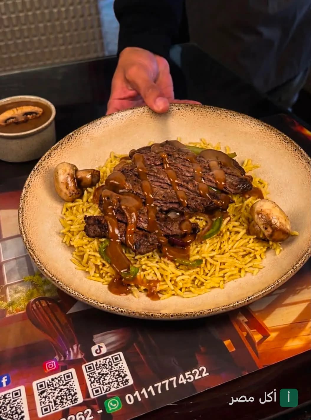 طبق أرز أصفر مع شرائح لحم مشوي وصوص المشروم في مطعم تريو آر بالإسكندرية.