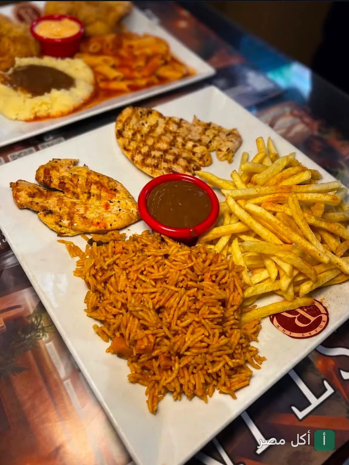 طبق مشويات دجاج مع أرز وبطاطس مقلية وصوص في مطعم تريو آر بالإسكندرية