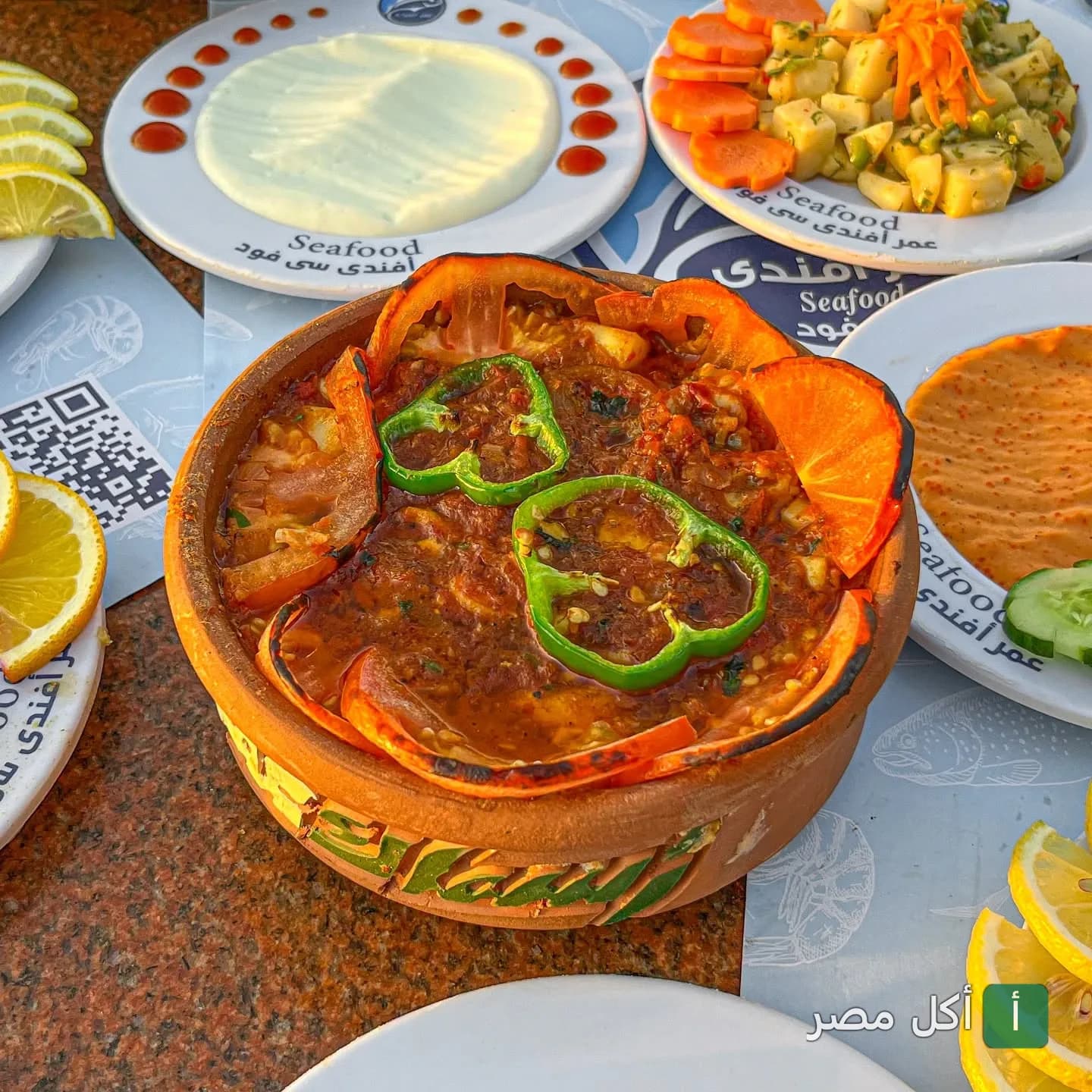 طاجن مأكولات بحرية في مطعم عمر أفندي بسيدي جابر الإسكندرية مع مقبلات متنوعة.