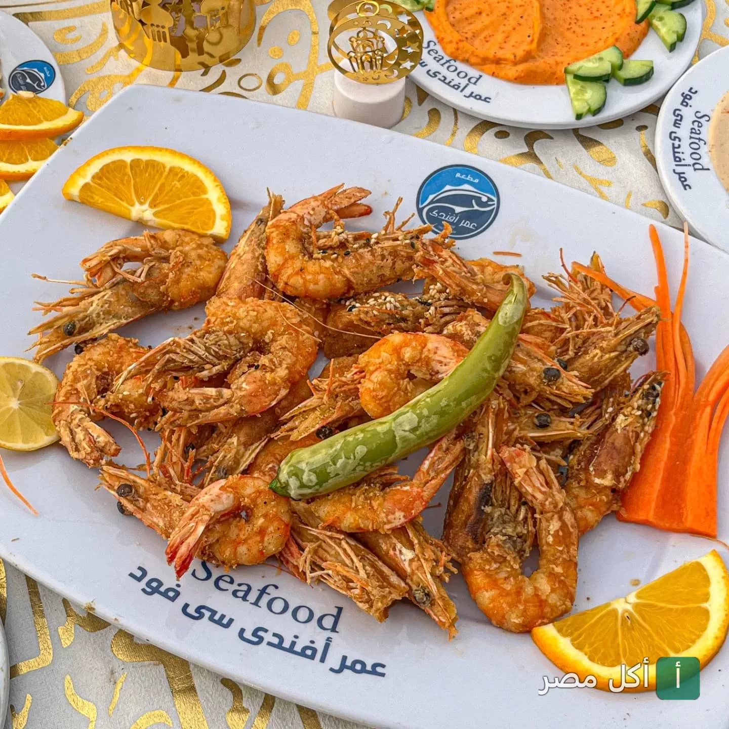 طبق جمبري مقلي ومزين بقطع البرتقال والفلفل في مطعم عمر أفندي بسيدي جابر الإسكندرية