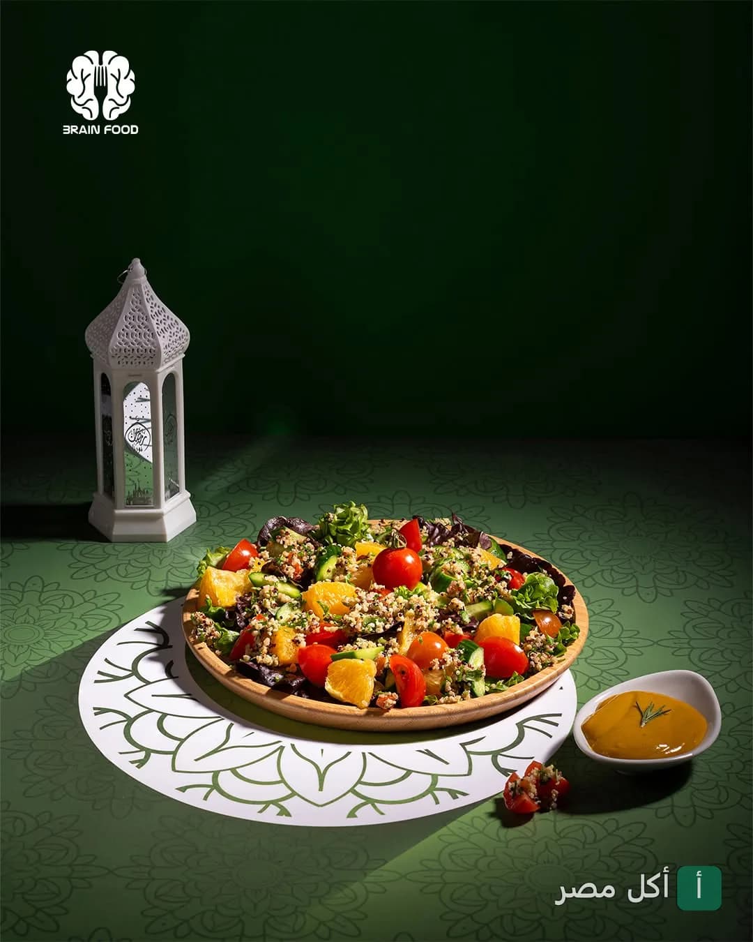طبق سلطة كينوا ملون مع طماطم وبرتقال بجانب فانوس رمضان في مطعم Brainfood بالإسكندرية.