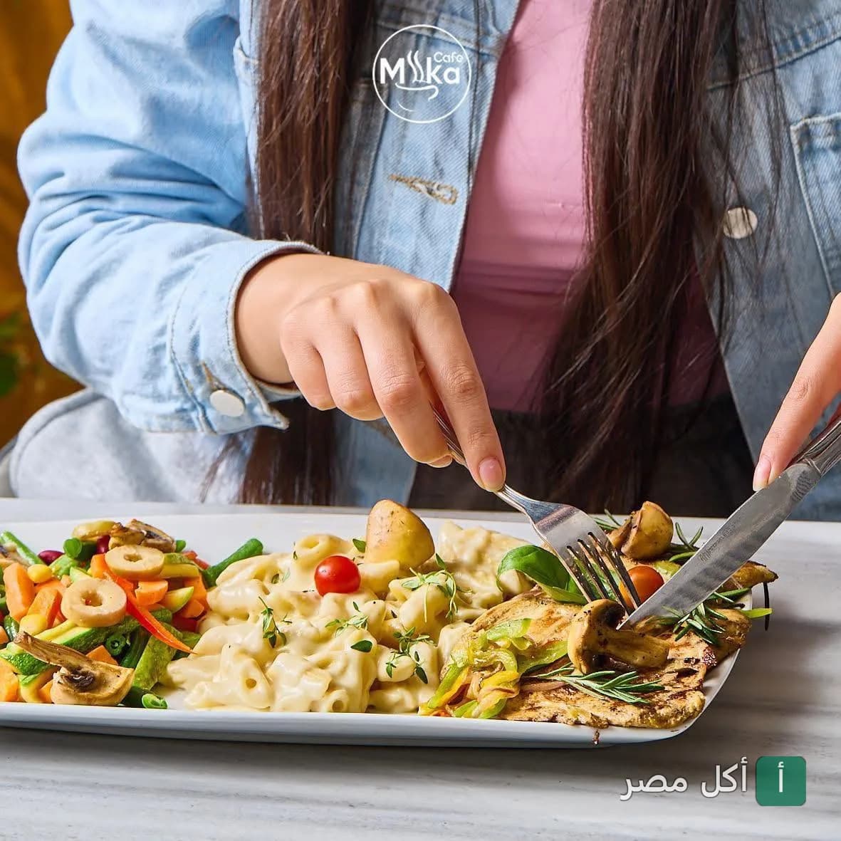 شخص يتناول طبق مكرونة بالصوص الأبيض مع الدجاج والخضروات في كافيه ميكا بالإسكندرية.
