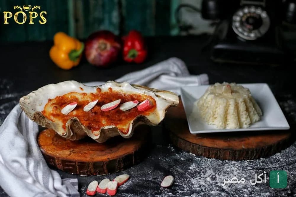 طبق مأكولات بحرية في صدفة كبيرة مع أرز في بوبس كافيه بسيدي بشر، الإسكندرية.