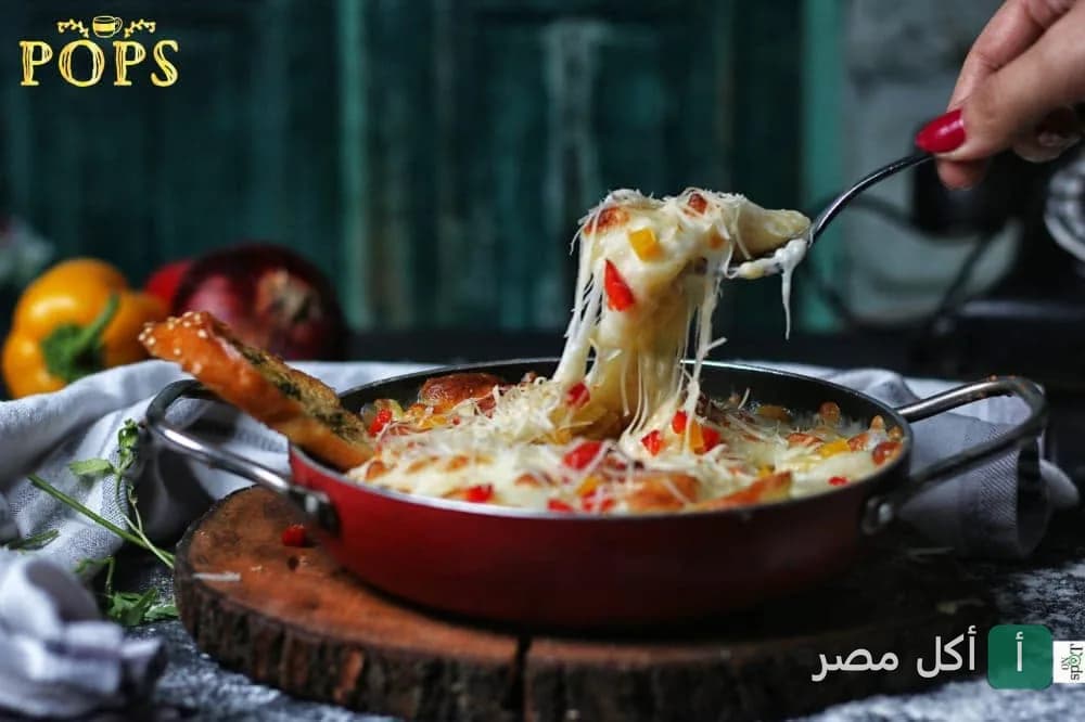 طبق ساخن من بوبس كافيه في سيدي بشر يظهر فيه الجبن الذائب يمتد من شوكة.