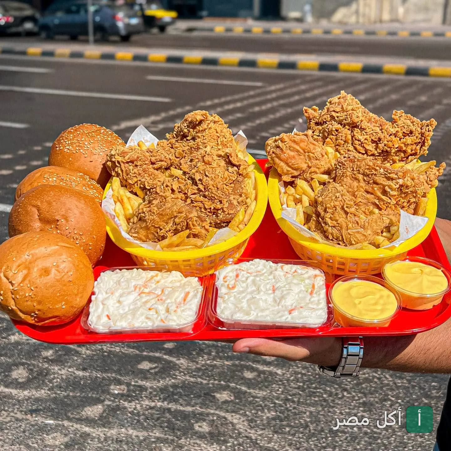 صينية مطعم كاركي بمحرم بك تحتوي على دجاج مقلي مقرمش، بطاطس محمرة، خبز كيزر، وسلطة كول سلو.