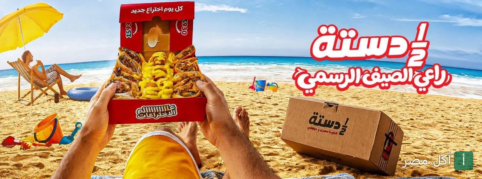 صورة غلاف لمطعم نص دسته تظهر شخصاً يحمل علبة وجبات متنوعة على شاطئ البحر في الإسكندرية.