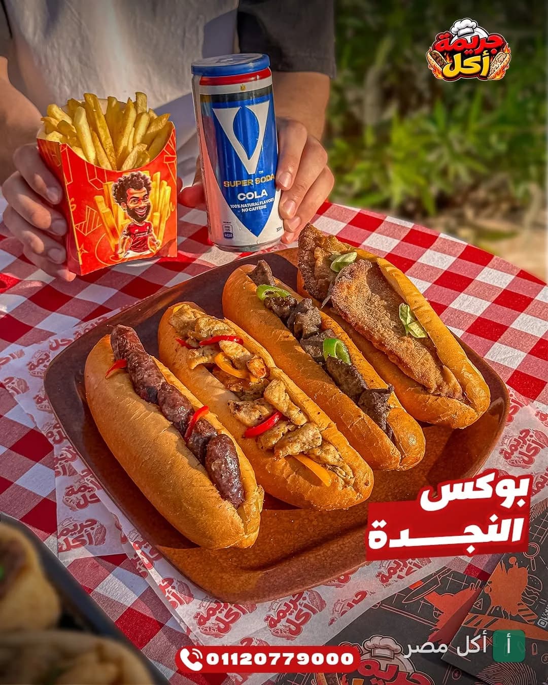 صينية بوكس النجدة من مطعم جريمة أكل في برج العرب تحتوي على ساندوتشات متنوعة مع بطاطس مقلية ومشروب غازي.