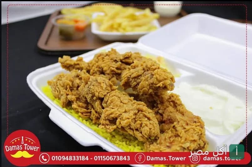وجبة دجاج مقرمش مع أرز أصفر وثومية في علبة تيك أواي من مطعم البرج الدمشقي ببرج العرب.