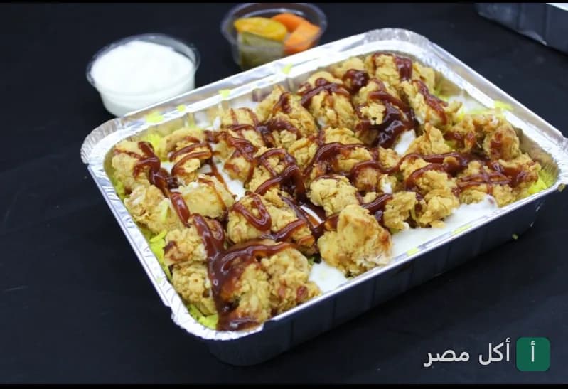 وجبة دجاج مقرمش مع صوص باربيكيو وأرز أصفر في مطعم البرج الدمشقي ببرج العرب.