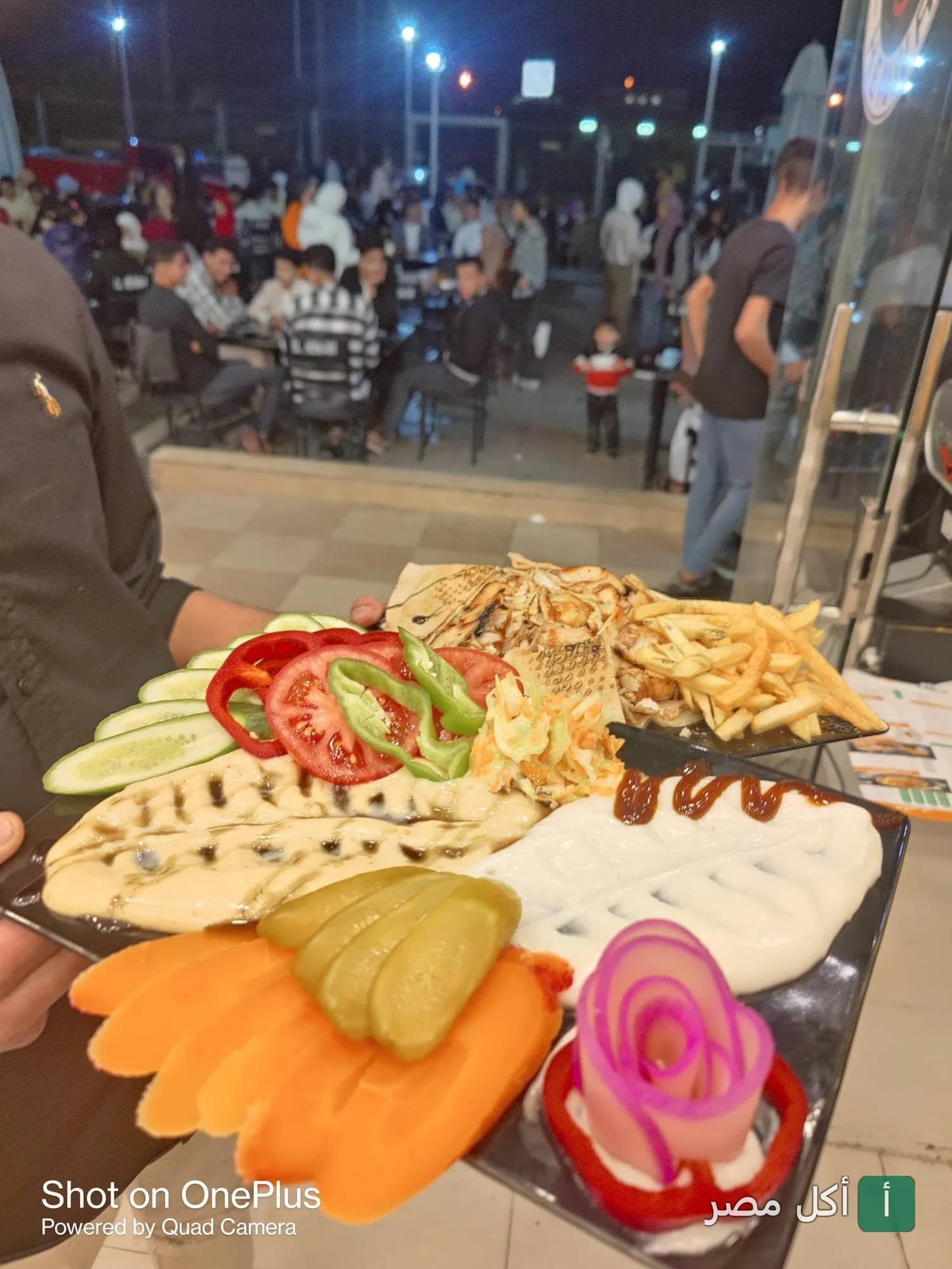 طبق مقبلات مشكل يضم طحينة، مخللات، وخضروات طازجة في مطعم الحناوي ببرج العرب.