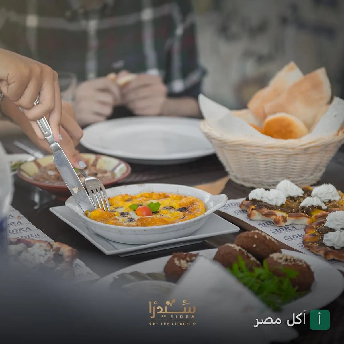 سفرة فطور متنوعة في مطعم وكافيه سيدرا ببرج العرب، تضم أطباق فول وفلافل ومخبوزات.